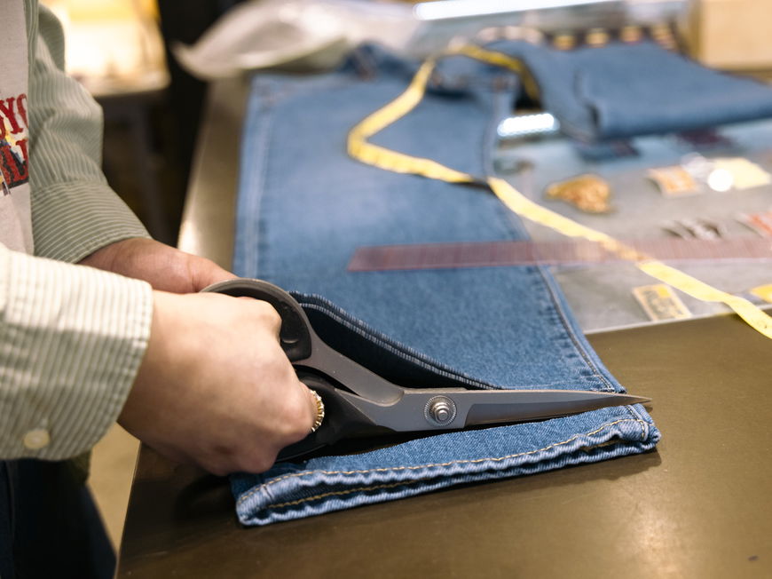 Person kürzt eine Jeans