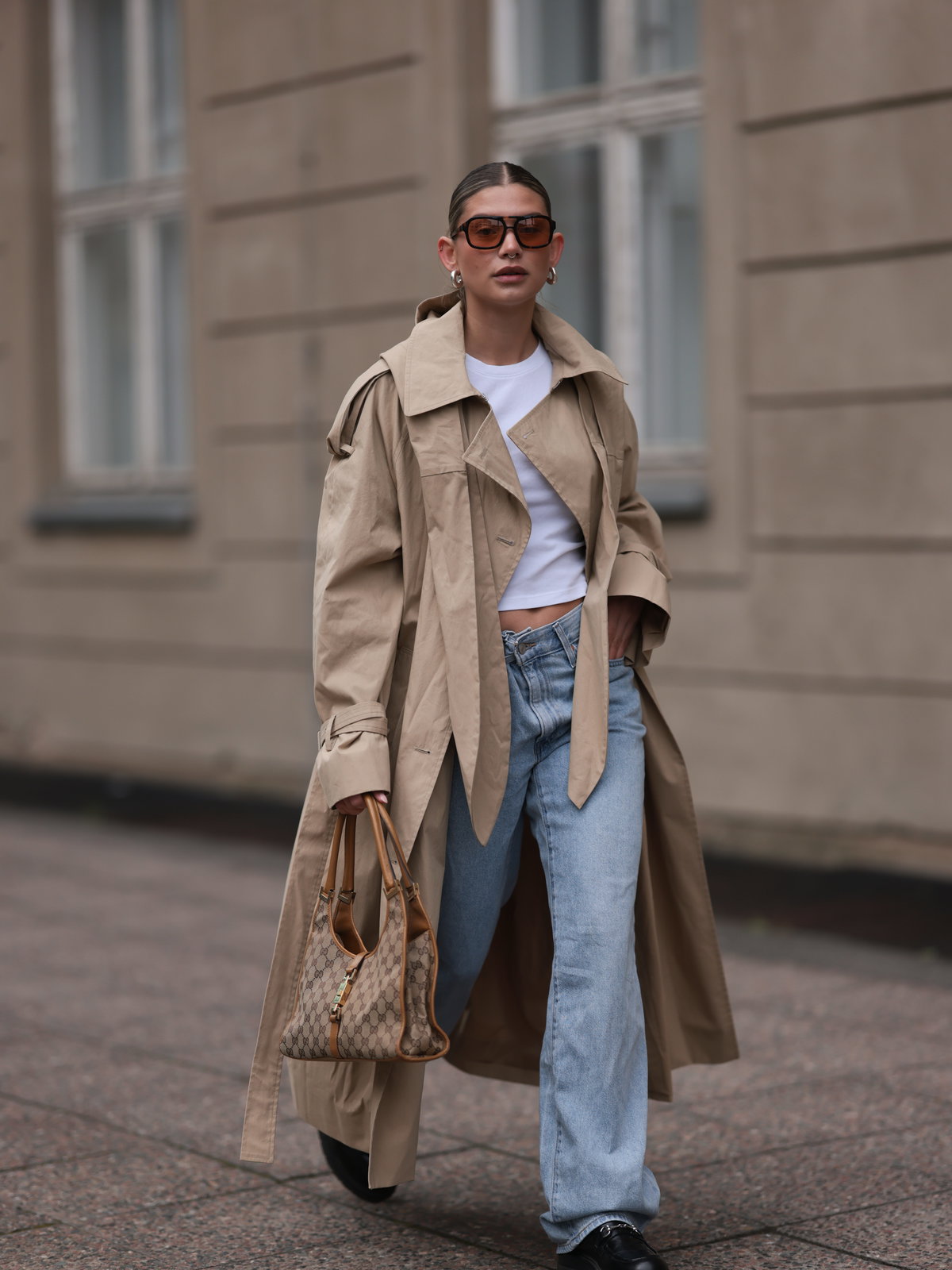 Frau in einem Trenchcoat mit Jeans