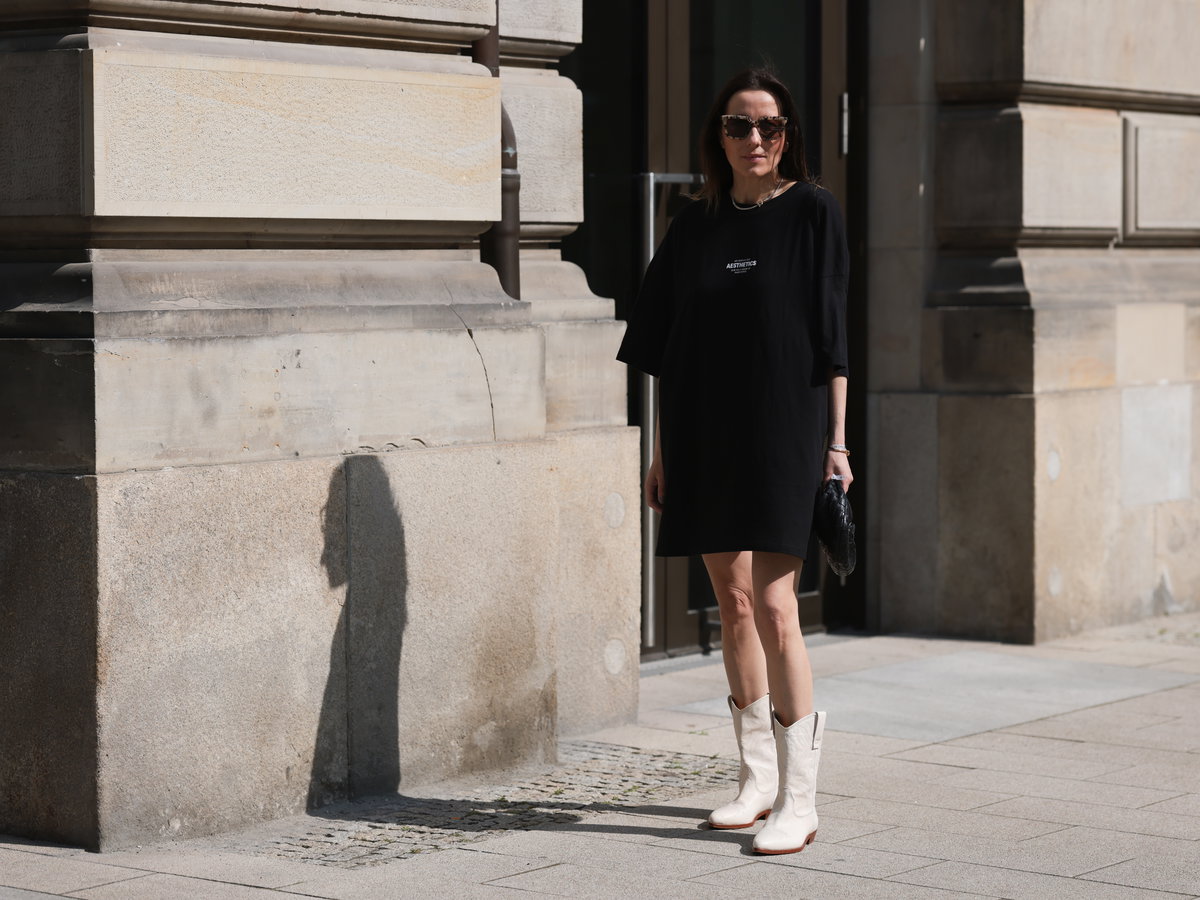 Frau in T-Shirt-Kleid mit Stiefeln