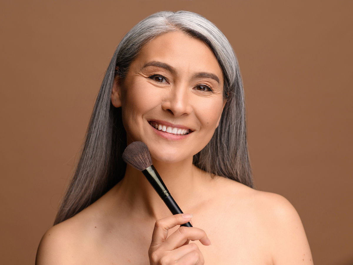 Ältere Frau mit Make-up Pinsel