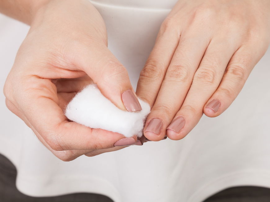 Nagellack von den Fingernägeln mit einem Wattepad entfernen