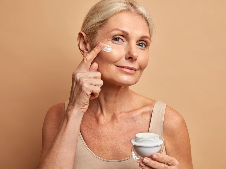 Frau trägt Creme aufs Gesicht