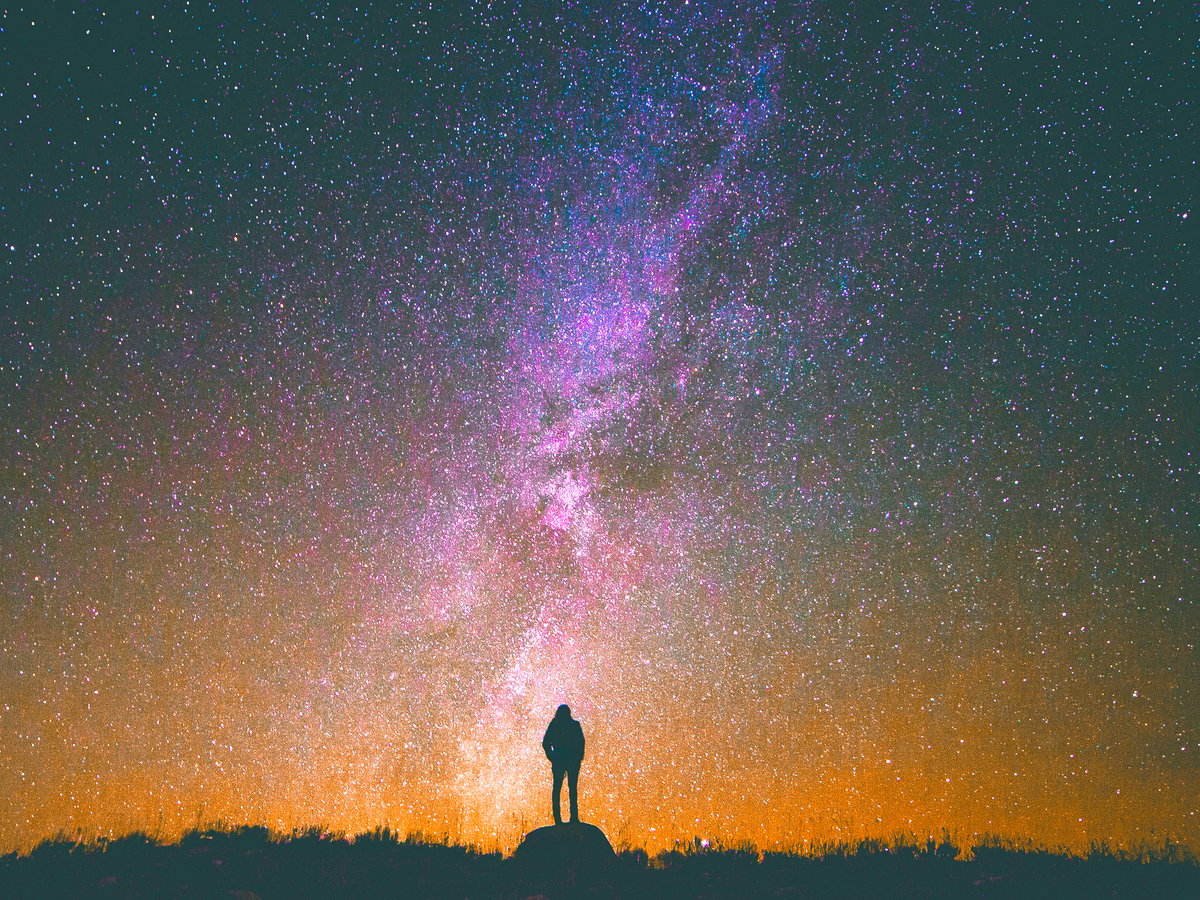 Frau steht unter Sternenhimmel