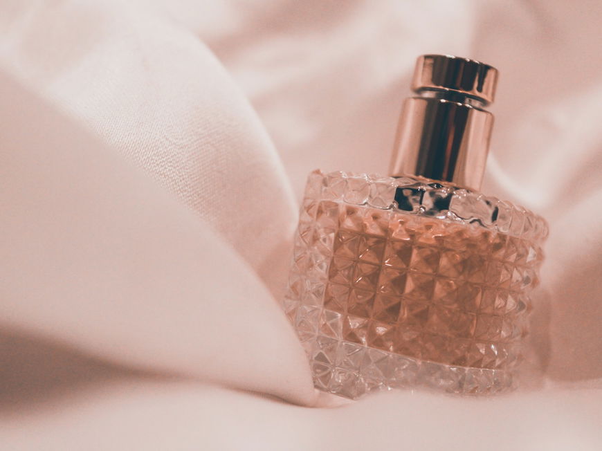 Parfum Flakon auf einem Tuch als Hintergrund