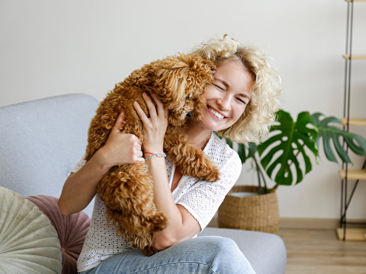 Frau kuschelt mit einem Hund.