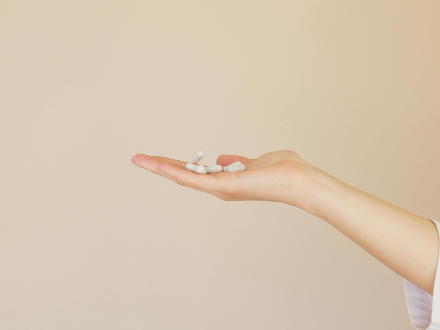 Frau hält Tabletten in der Hand.
