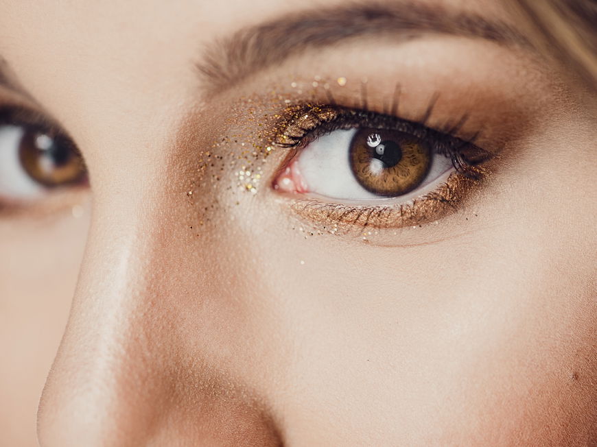 Frau trägt ein glitzerndes Augen-Make-up.