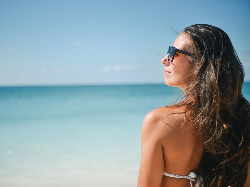 Junge Frau genießt die Sonne am Strand
