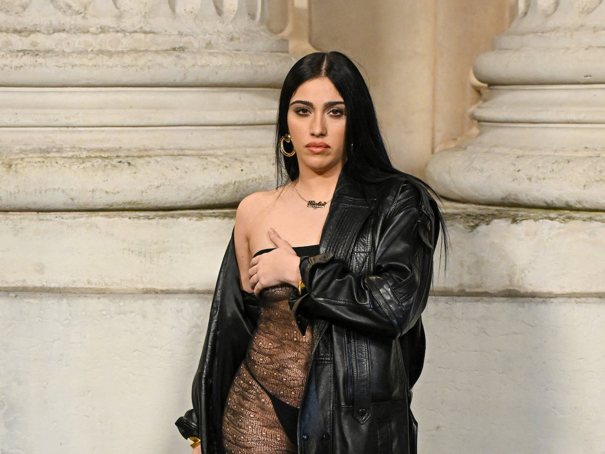 Lourdes Leon in einem transparenten Kleid mit Leder-Trenchcoat.