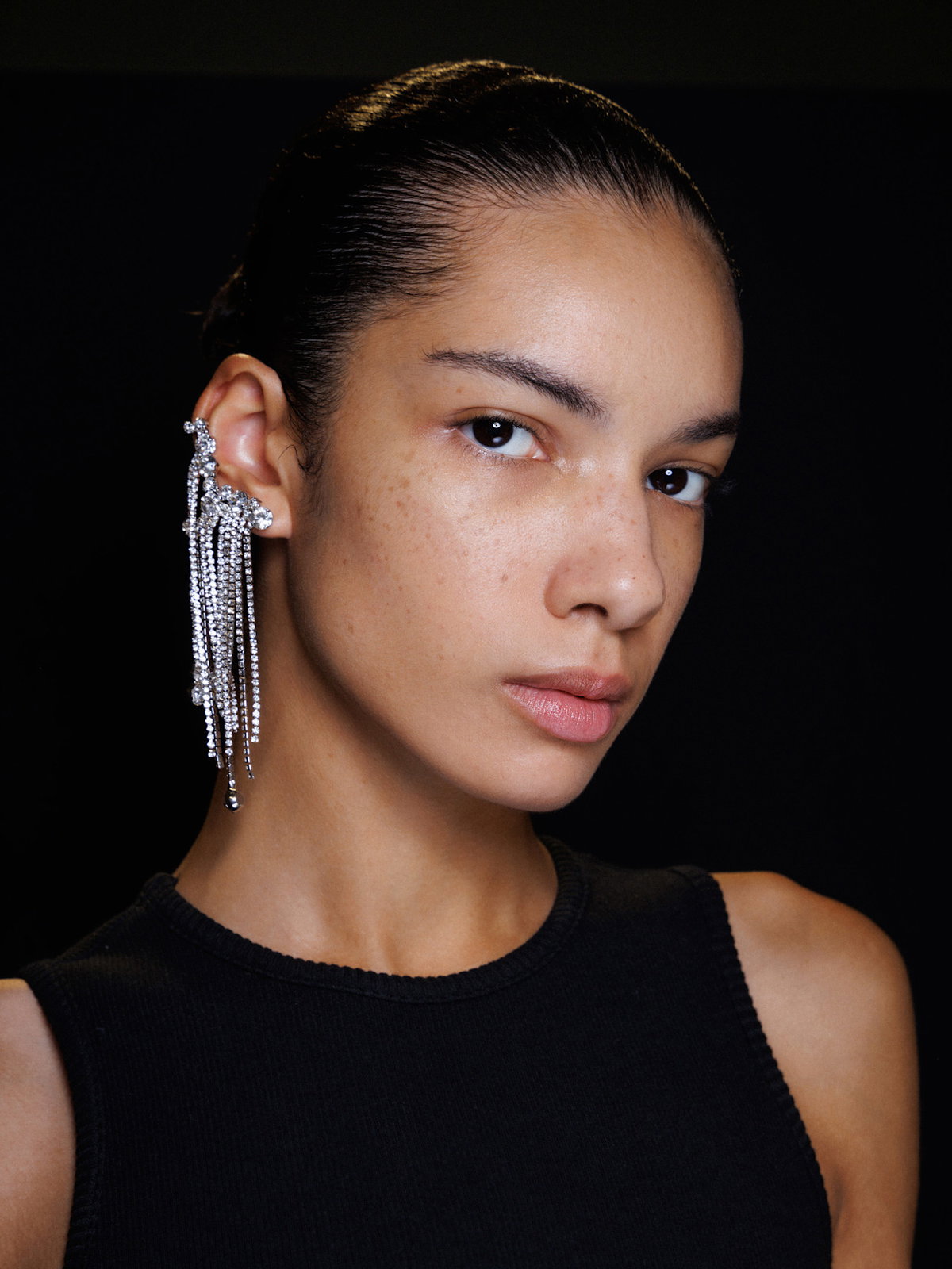 Portrait einer Frau mit glitzernden, langen Ohrringen.