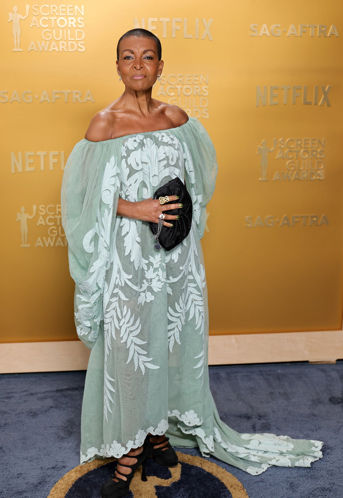 Adjoa Andoh in einem pastellgrünen Kleid mit weiten Ärmeln.