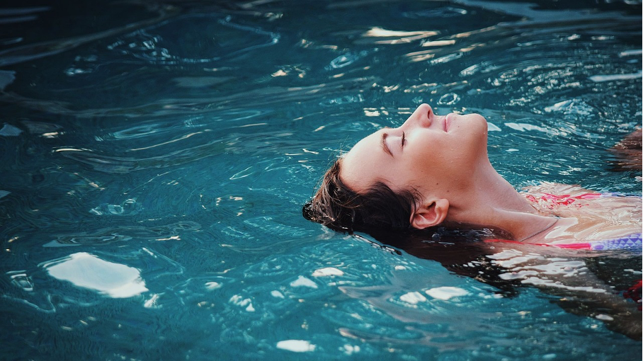 Eine Frau lässt sich im Pool treiben