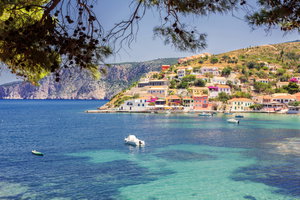 Die Küste von Kefalonia mit bunten Häusern und Booten auf dem Wasser.
