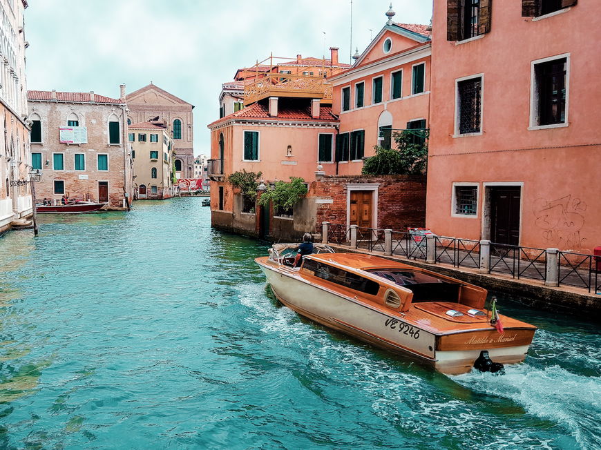 Ein Kanal in Venedig mit bunten Häusern und einem Boot.