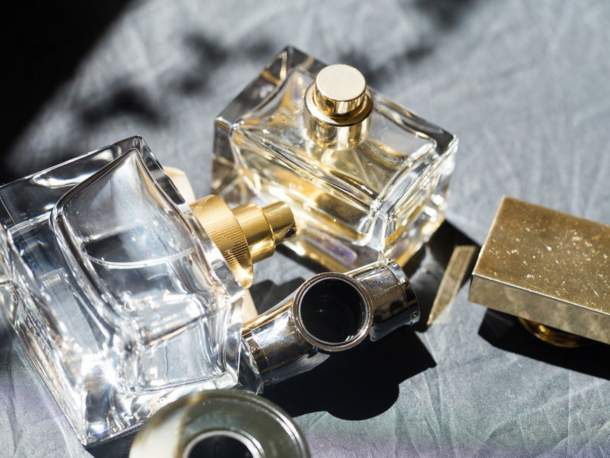 Parfum Flakons liegen auf einem grauen Hintergrund.