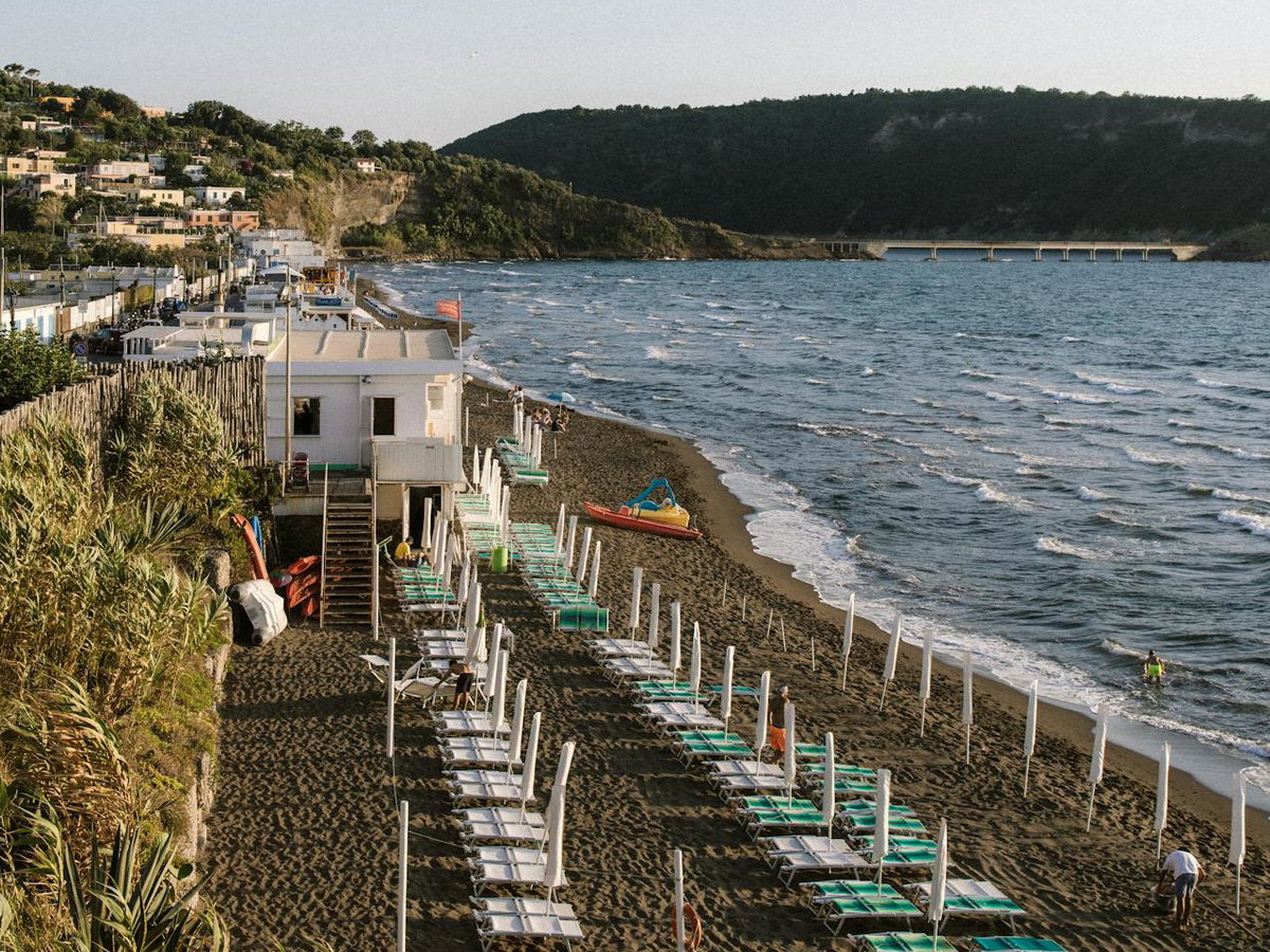Der Strand von Procida mit Liegen und Sonnenschirmen.