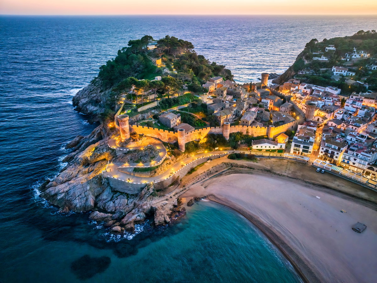 Ein Blick auf einen Ort der Costa Brava bei Dämmerung aus der Vogelperspektive.