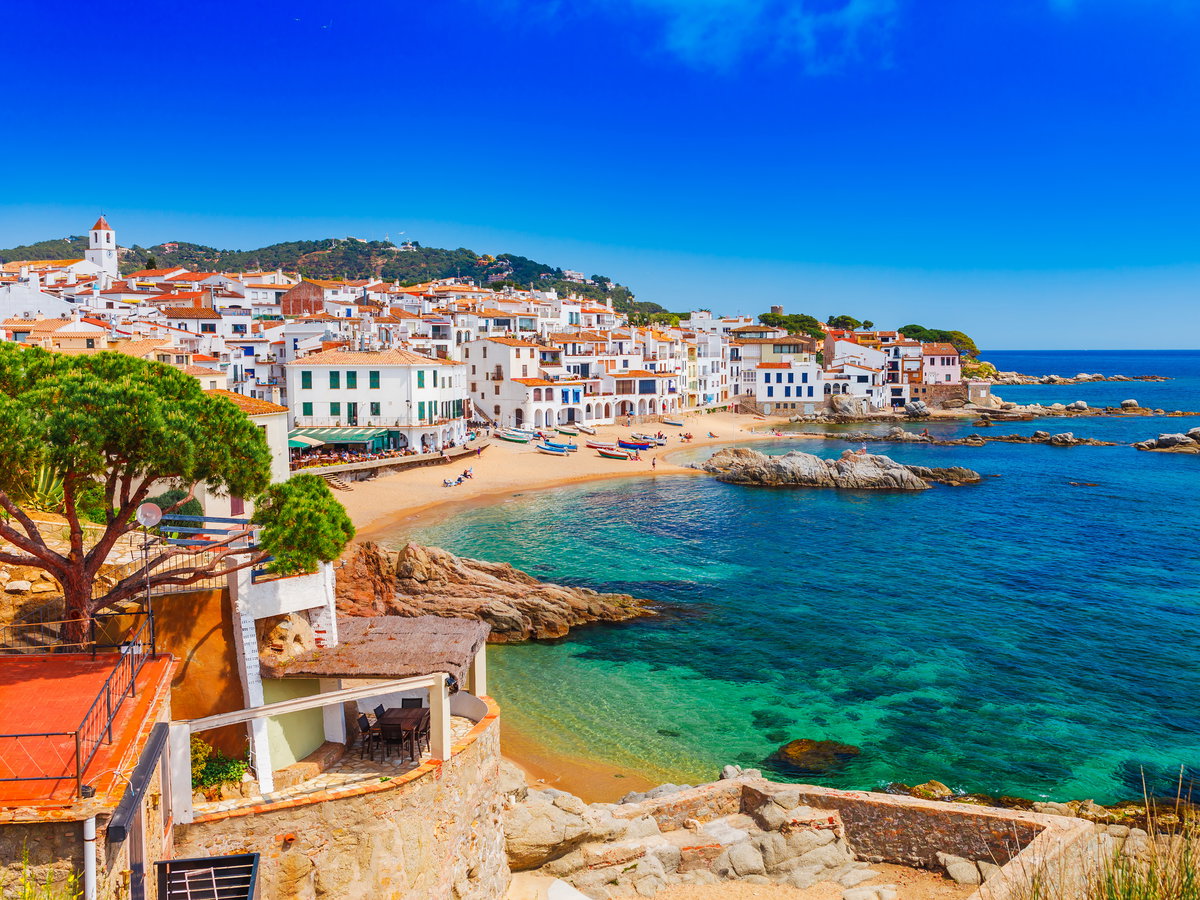 Die Küste mit weißen Häusern am Sandstrand der Costa Brava.