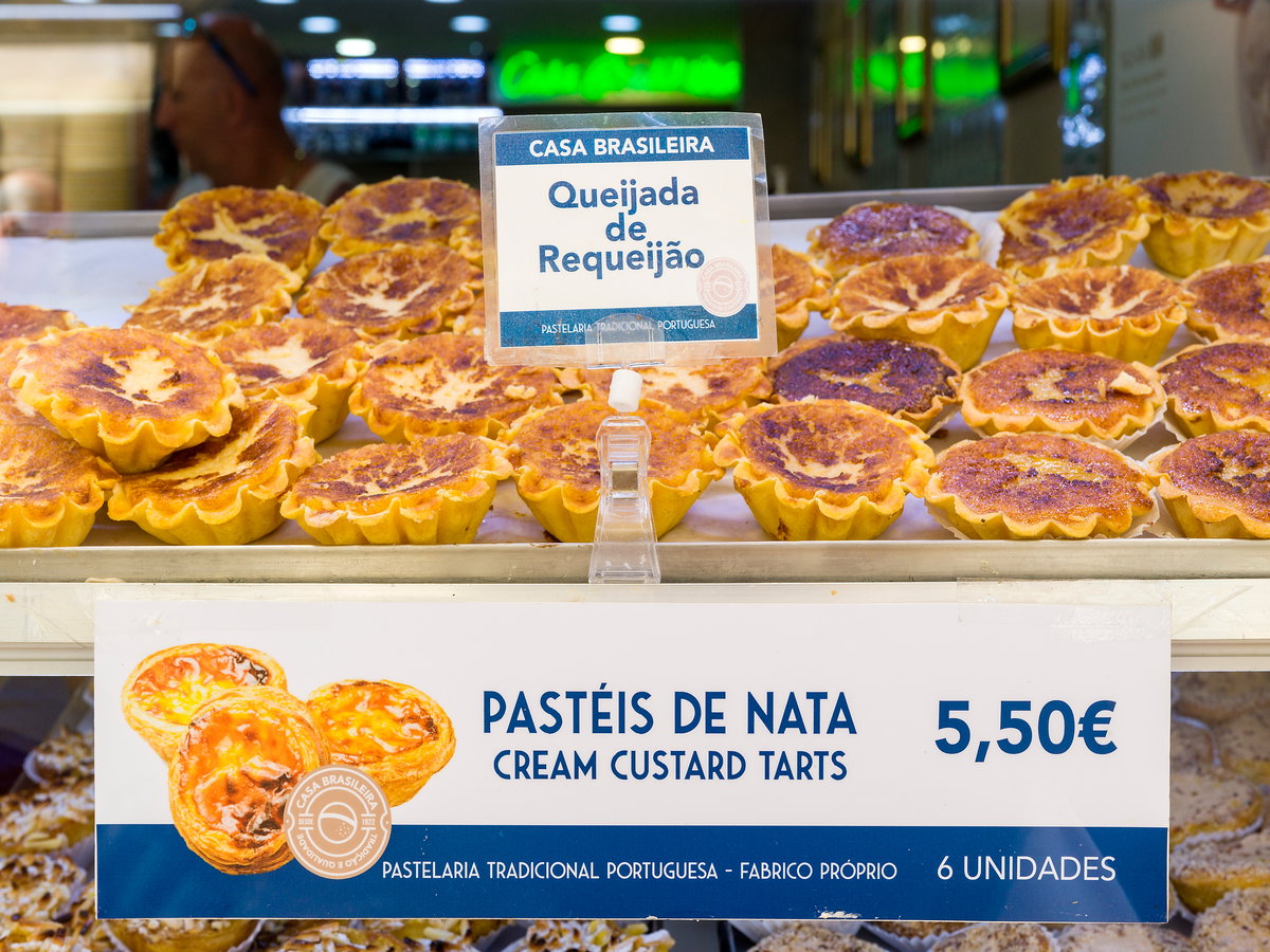 Pasteis de Nata hinter einer Glasscheibe in einer Bäckerei.