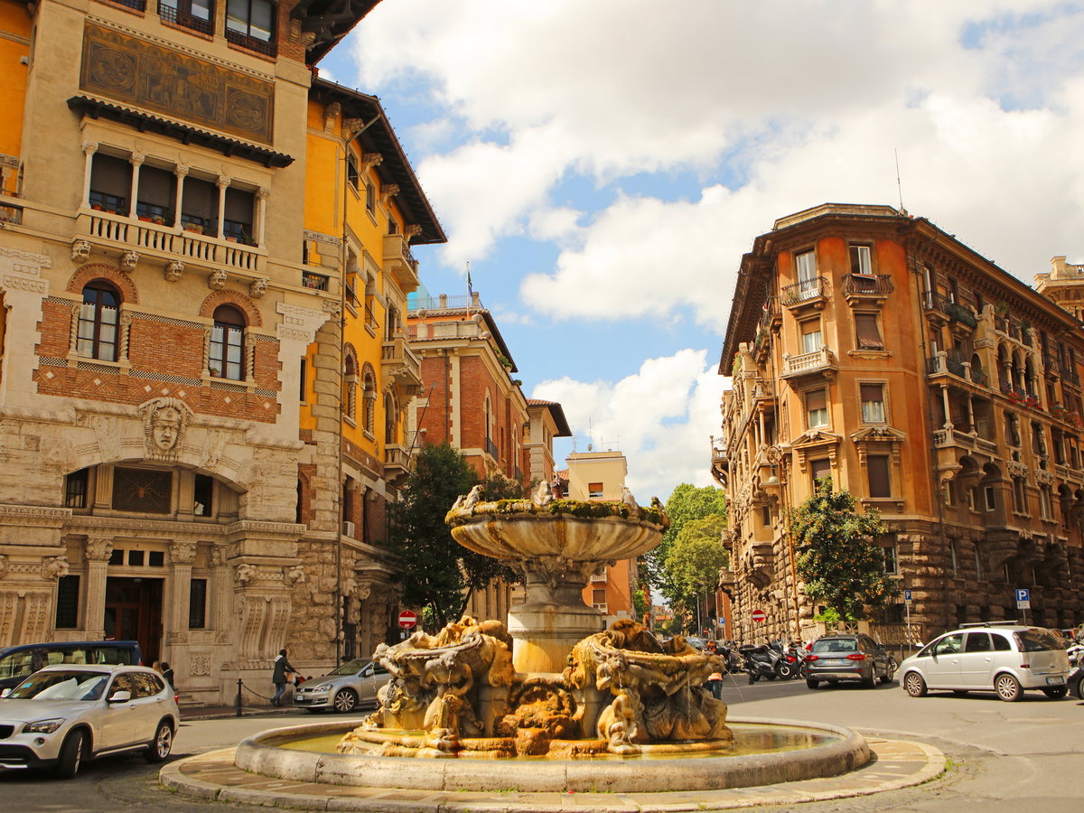 Das Quartiere de Coppede in Rom mit gelben alten Häusern und einem Brunnen in der Mitte.