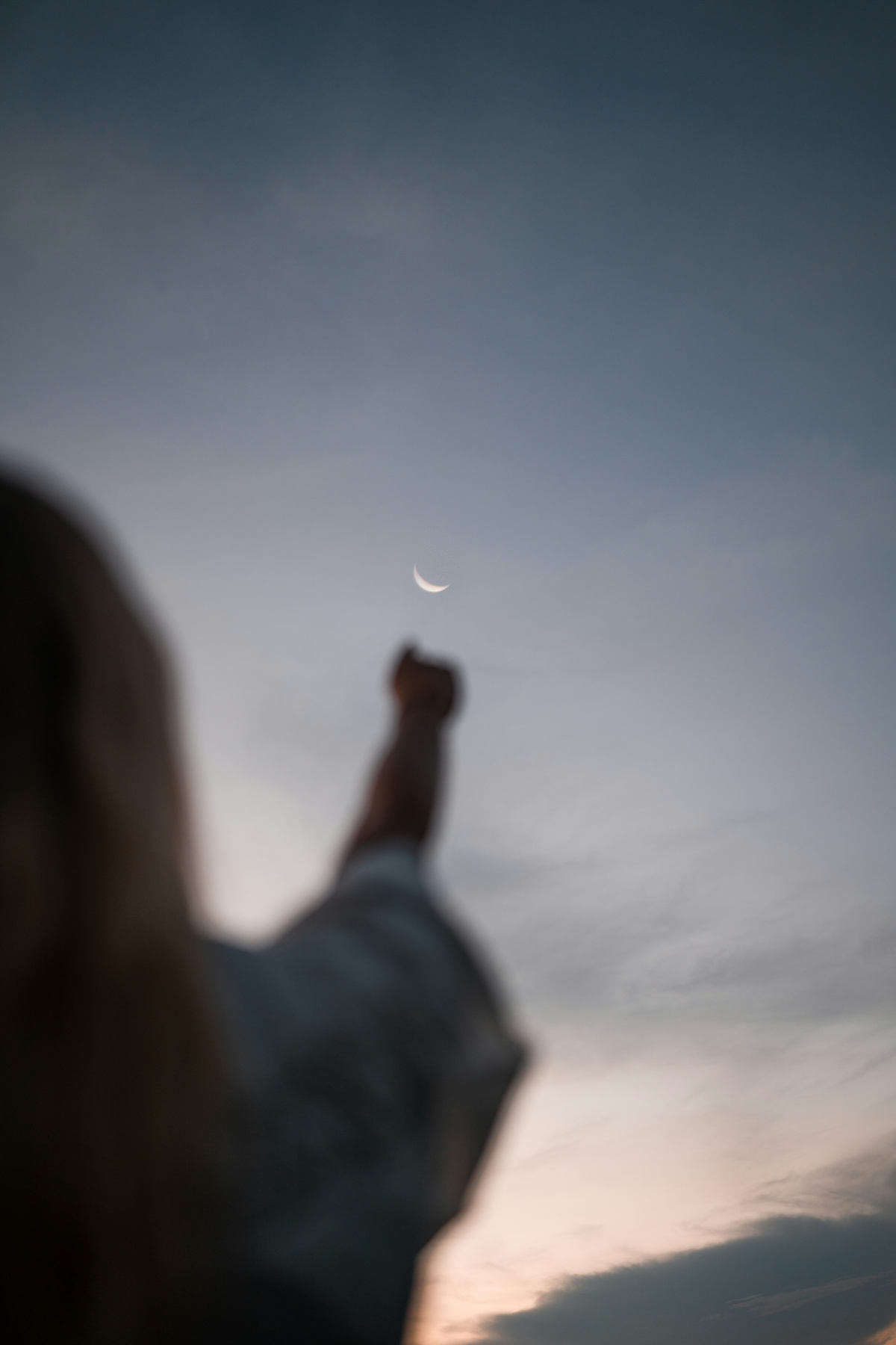 Frau streckt Arm in den Himmel