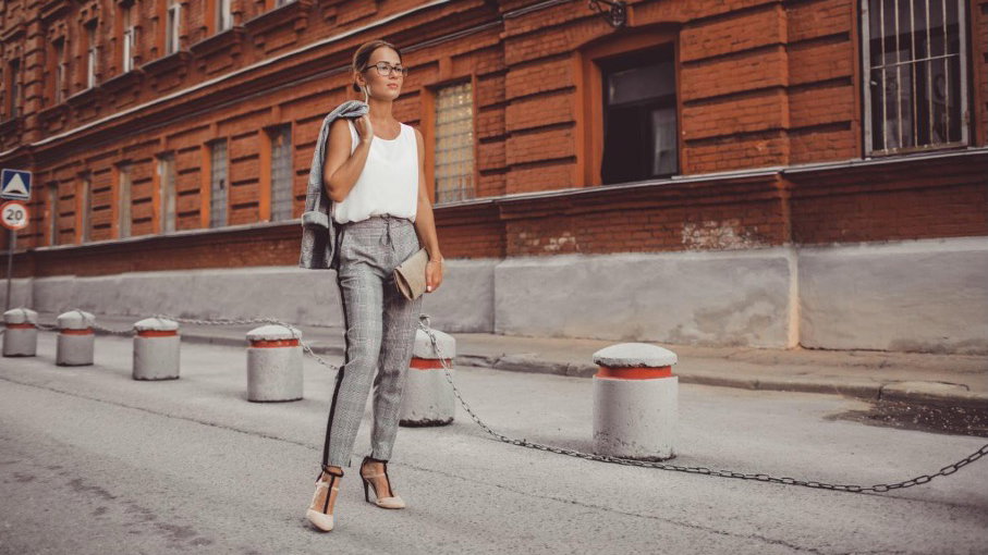Frau läuft in stylischem Outfit auf der Straße