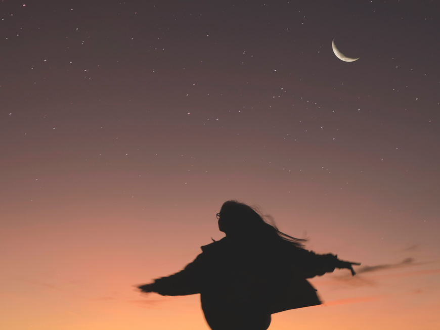 Frau tanzt unter Mondhimmel