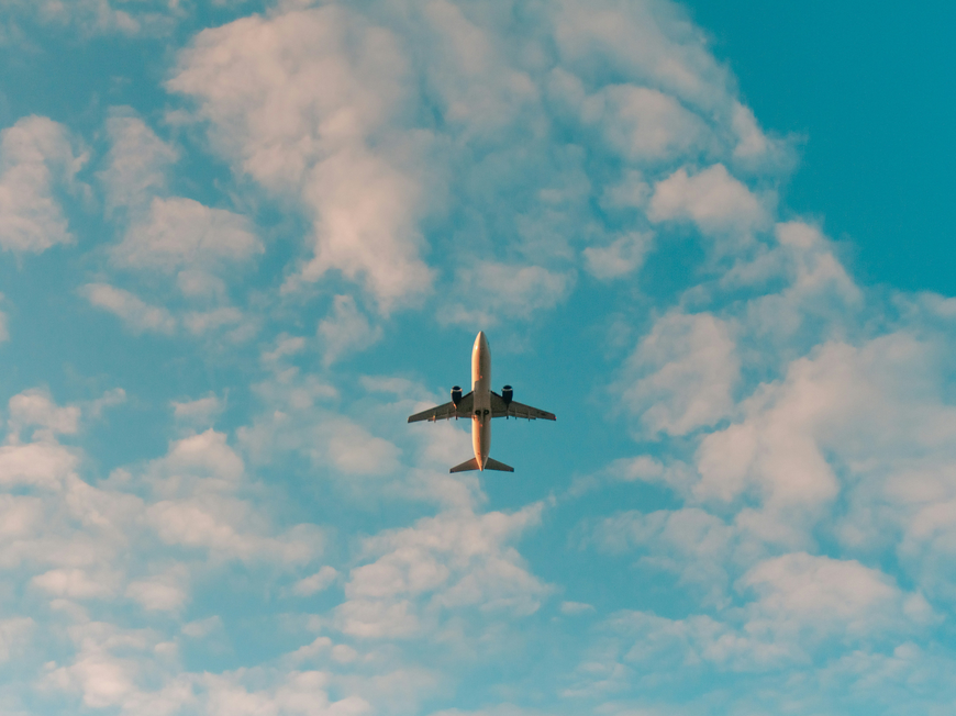 Flugzeug unter blauem Himmel mit Wolken