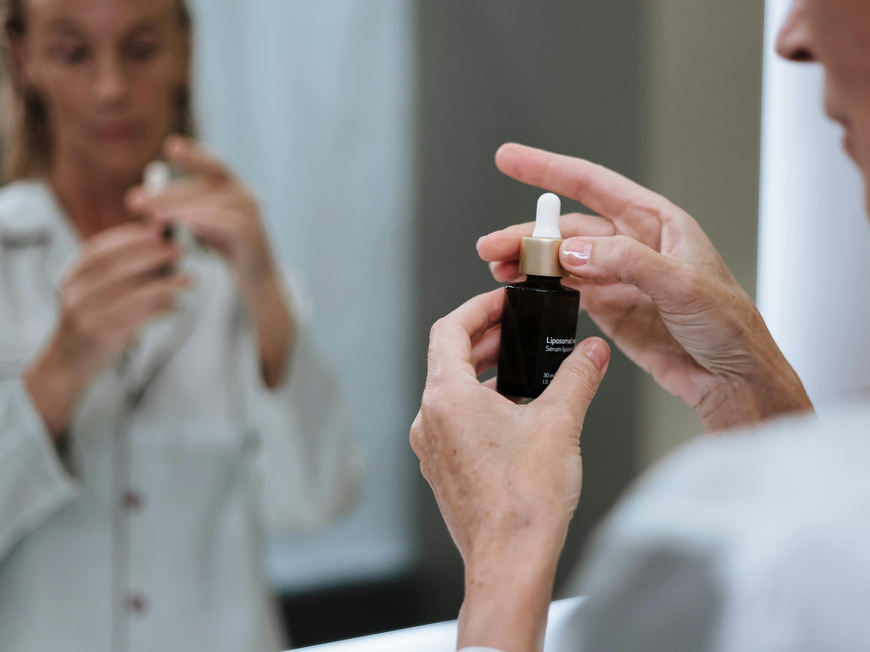 Frau hält Hautpflegeserum in der Hand