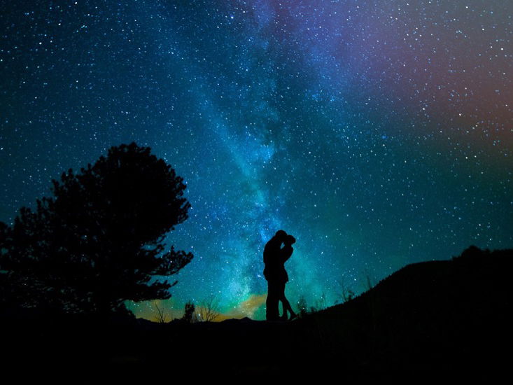 Ein Paar steht unter einem Sternenhimmel