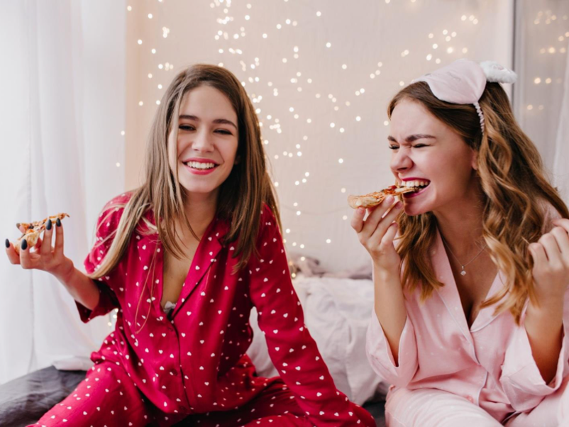 Zwei Freundinnen essen gemeinsam Pizza