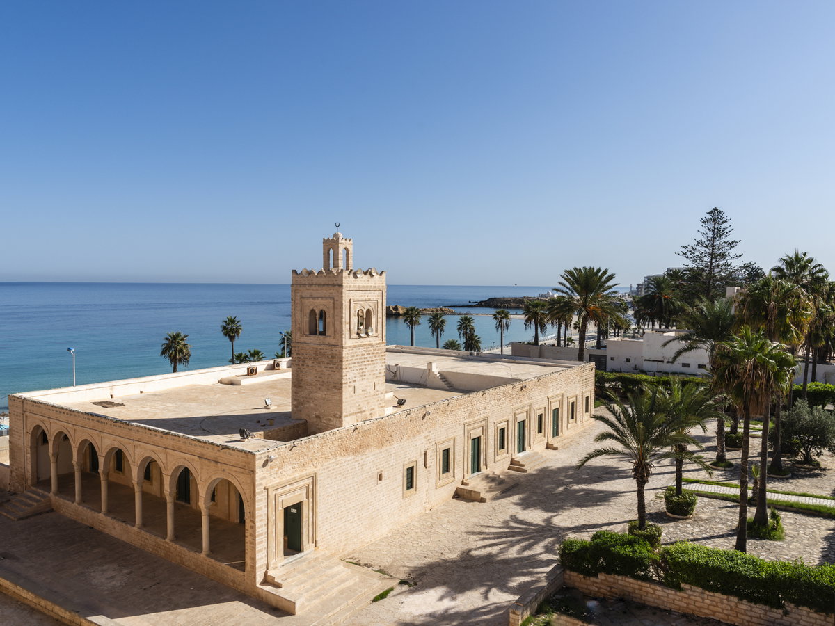 Große Moschee von Monastir in Tunesien mit Palmen drum herum.