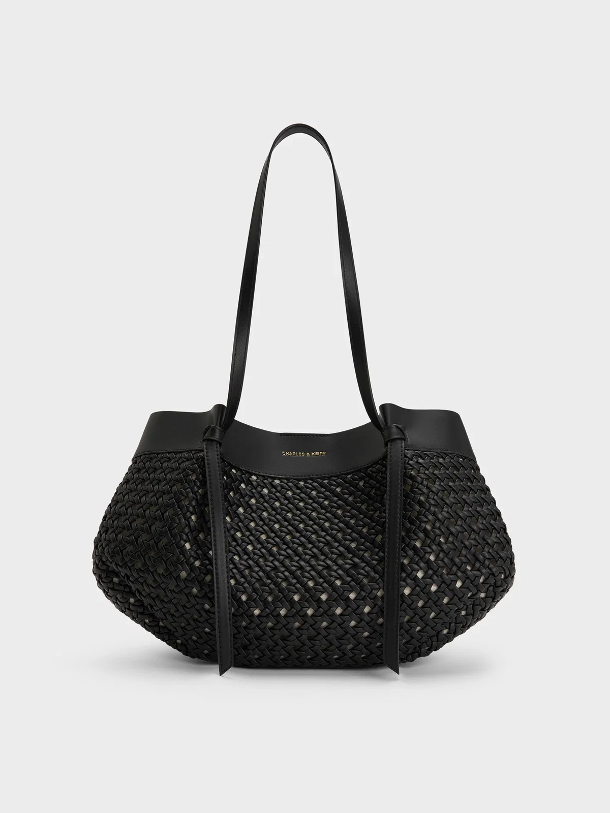 Gewebte Tote Bag in Schwarz mit langen Henkeln vor einem hellen Hintergrund.