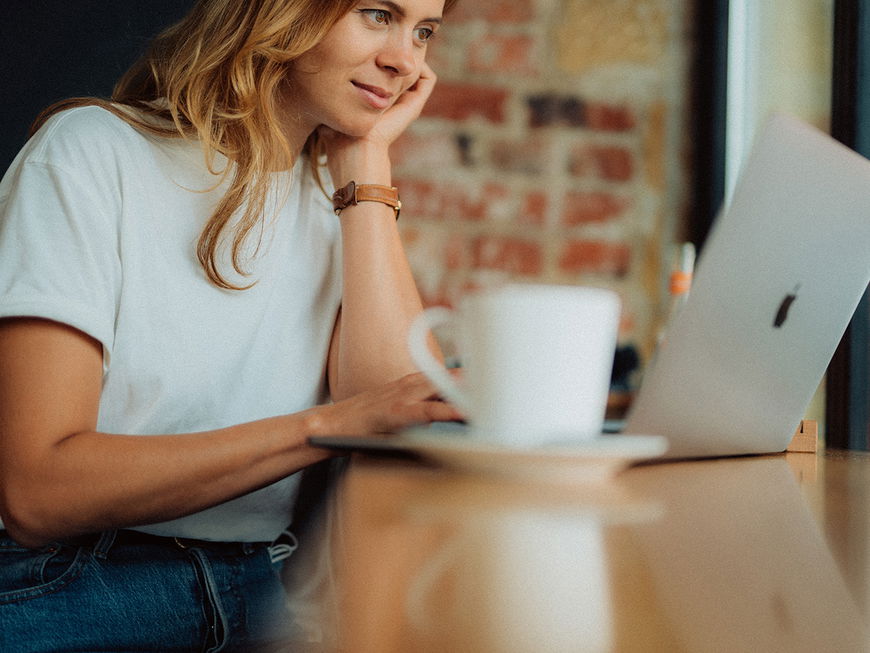 Eine Frau sitzt an ihrem Laptop