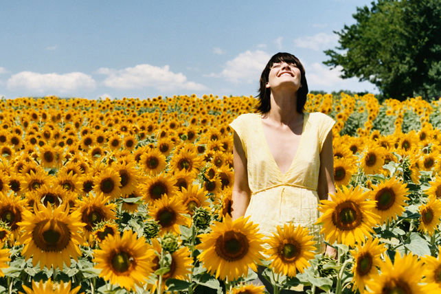 Junge Frau in Sonnenblumenfeld