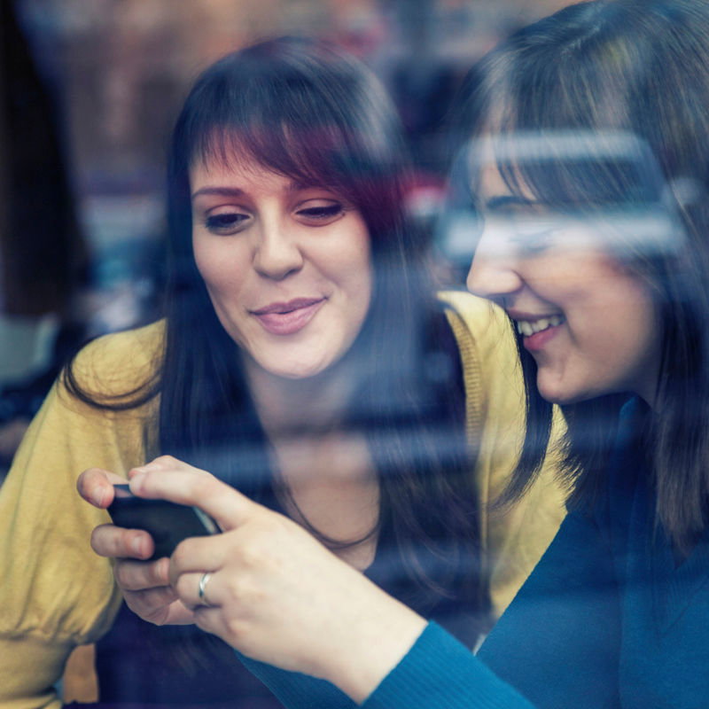 Junge Frauen nutzen Instagram auf ihren Smartphones