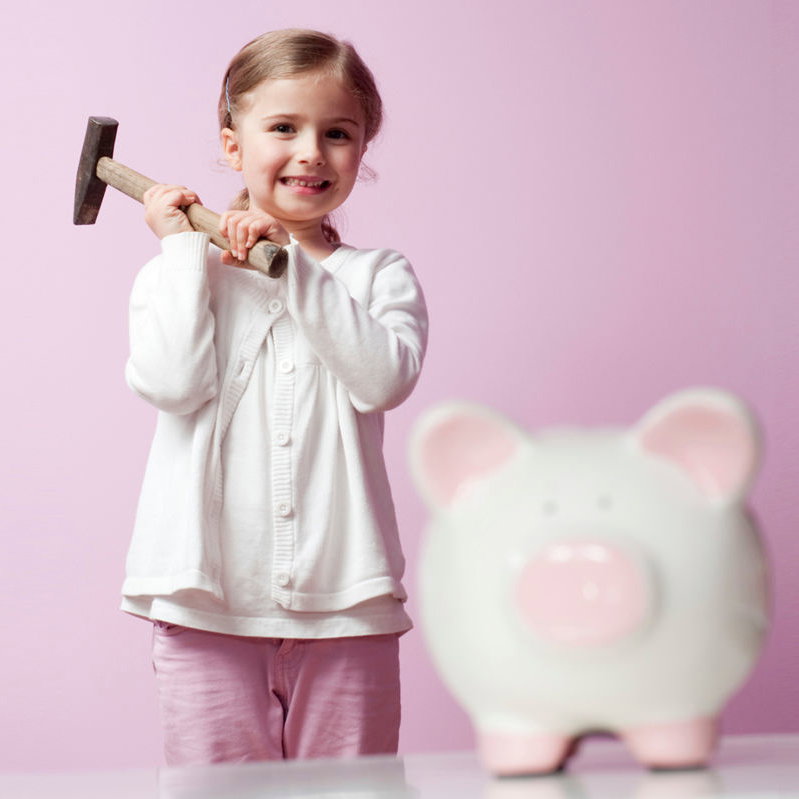 Mädchen mit Hammer hinter Sparschwein