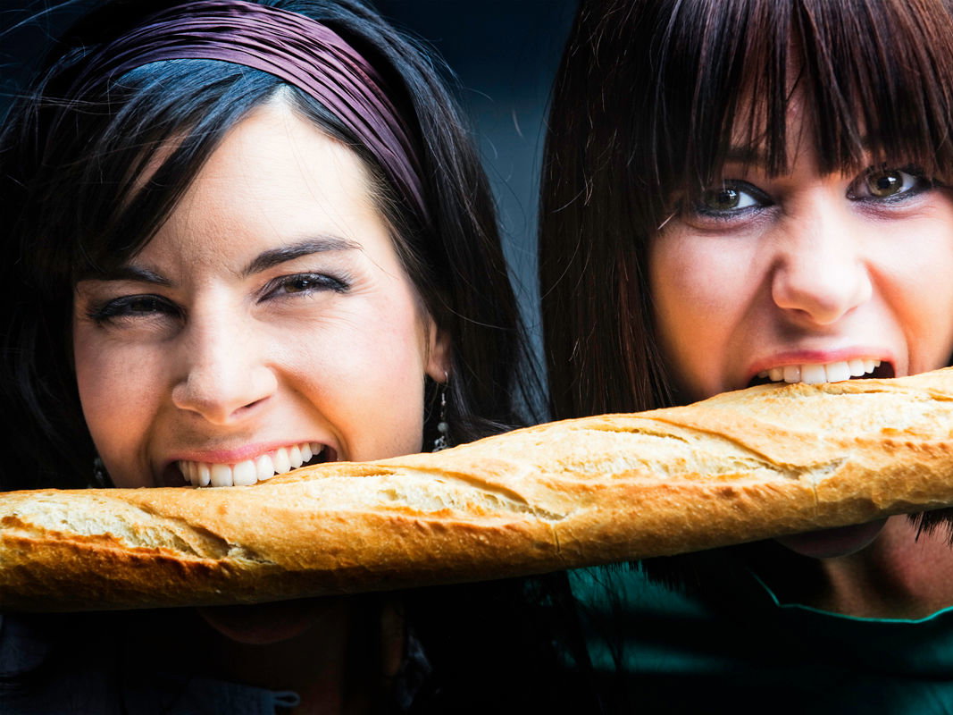 Junge Frauen beißen in Baguette