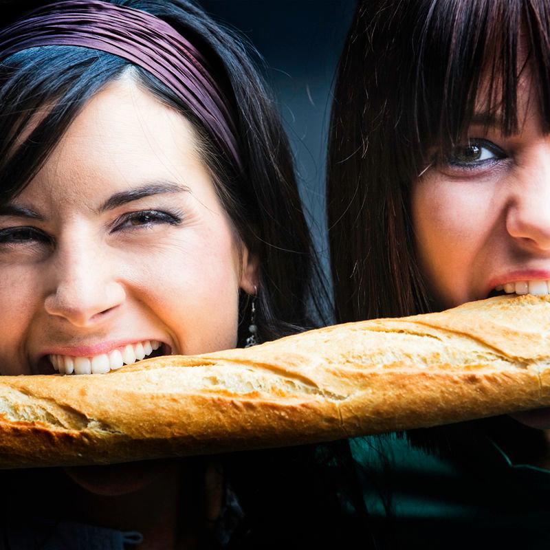 Junge Frauen beißen in Baguette