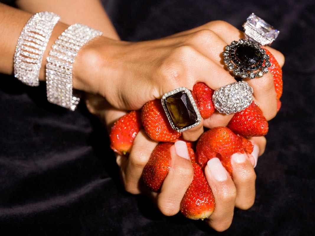 Frau mit großen Ringen hält Erdbeeren