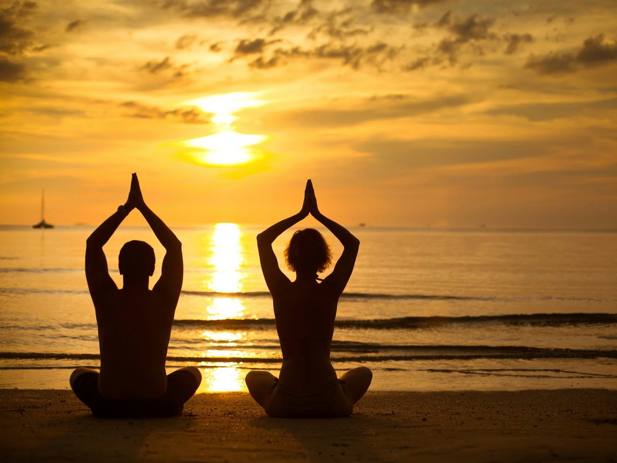 Partner-Yoga im Sonnenuntergang