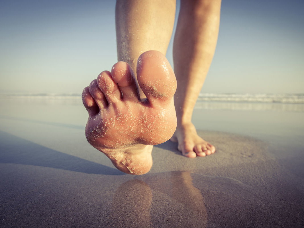 Frau barfuß am Strand