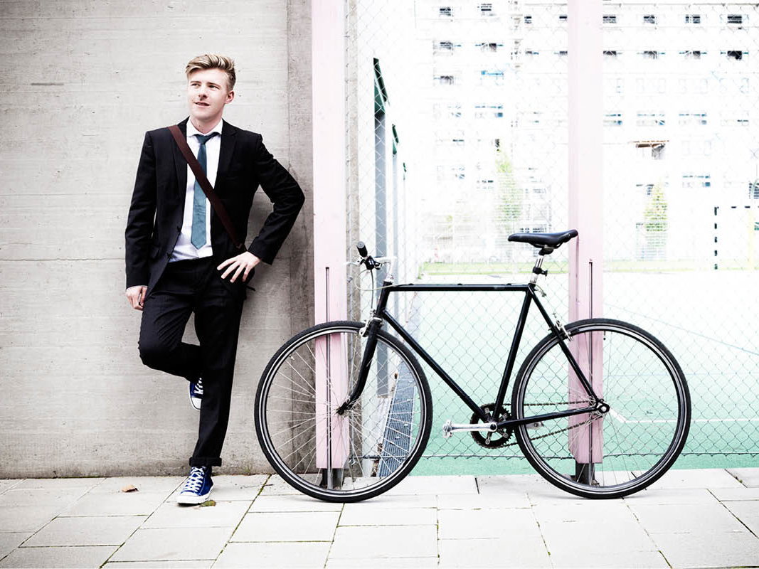 Mann im Anzug vor dem Fahrrad
