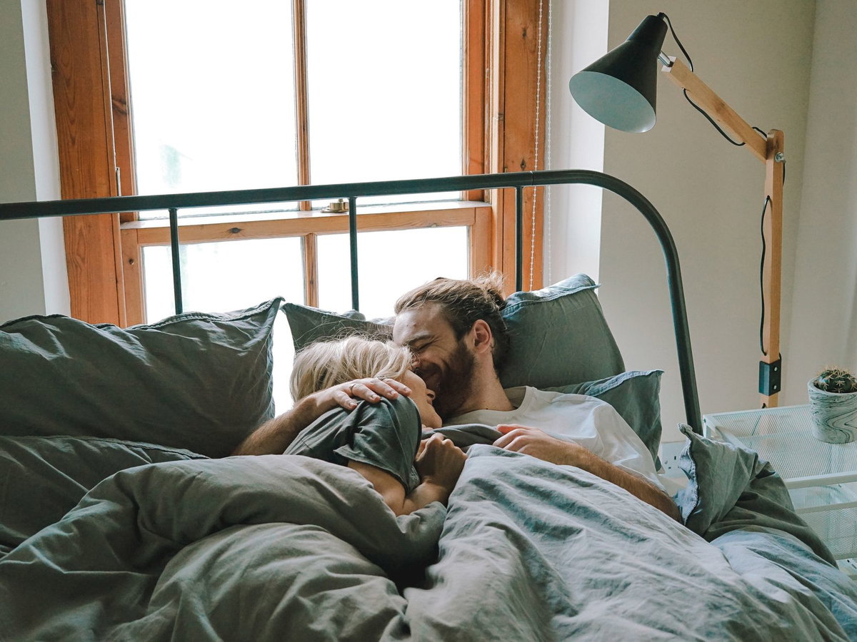 Paar kuschelt im Bett